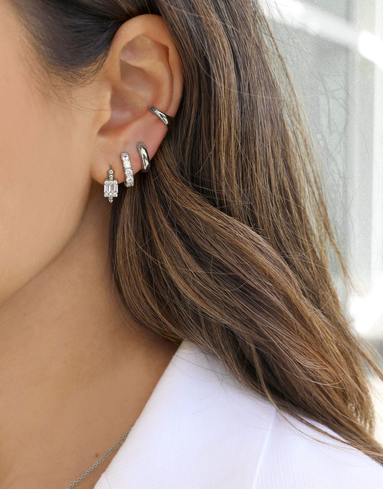 luxury silver huggie earrings stacked. showcasing carrie, bailey, camille and our sophiya cuff stack
