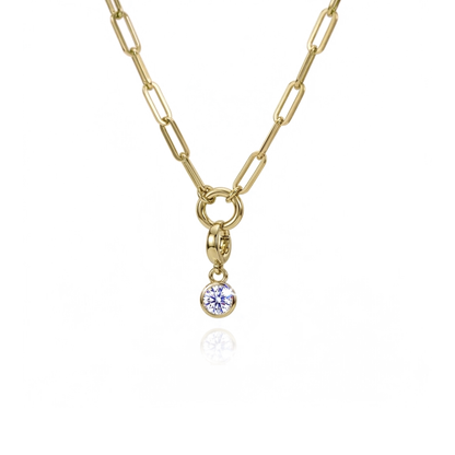 A gold paperclip chain necklace with a small round bezel-set blue gemstone pendant, shown on a clean white background with a subtle reflection.