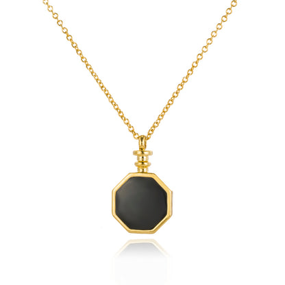 A detailed close up of a gold o-shape chain with octangular pendant in black enamel.