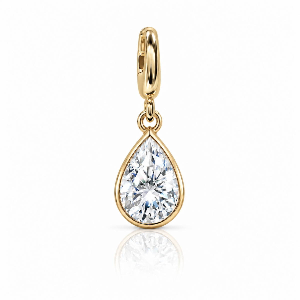 A gold teardrop pendant charm featuring a brilliant-cut clear gemstone in a bezel setting, suspended from a polished gold bail, shown on a white background with a soft reflection below.