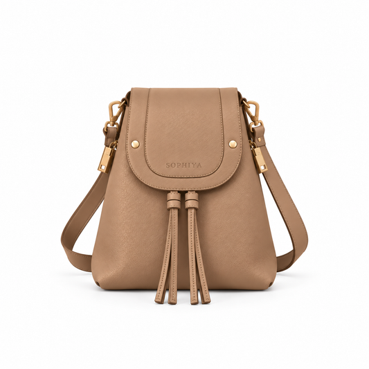 A tan leather bucket bag with a front flap, gold-tone hardware, and a tassel detail on the front, shown against a plain white background.