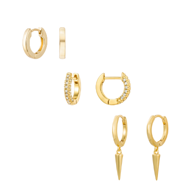 A detailed studio shot of 
 18k gold plated Huggie earrings, including spiked dagger huggie, cubic zirconia huggies and basic gold Huggies stacked