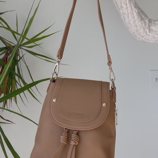 A video illustrates a number of small personal items fitting inside of Sophiya Zoe Shoulder Bag. A water bottle fits only in Sophiya Sam Medium Backpack. 