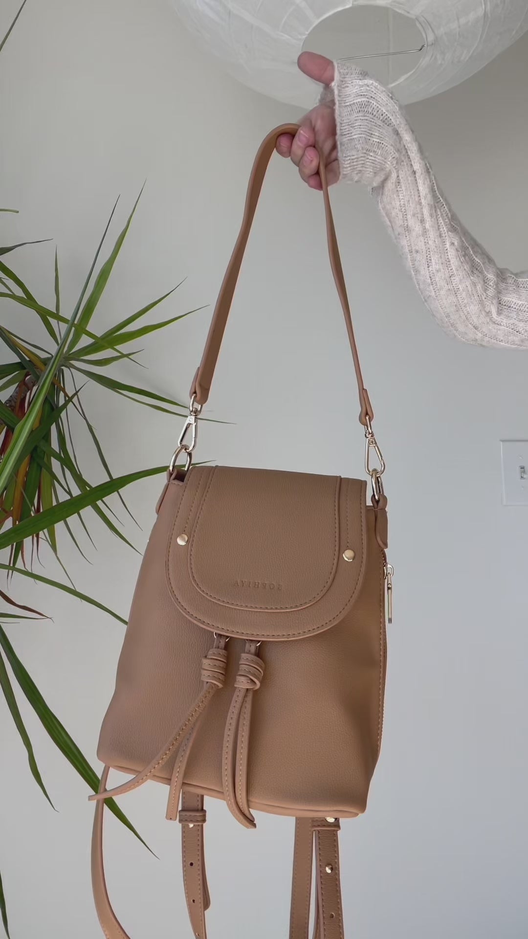 A video illustrates a number of small personal items fitting inside of Sophiya Zoe Shoulder Bag. A water bottle fits only in Sophiya Sam Medium Backpack. 