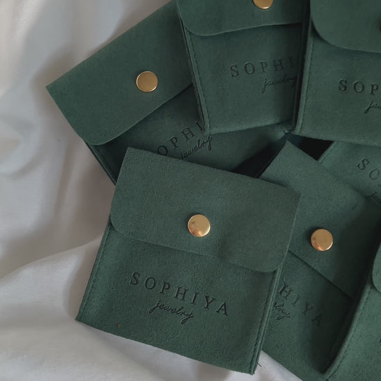 Quick cuts of unboxing silver jewelry from dark green jewelry pouches, high quality and eco friendly accessories shimmer and dazzle in the light.
