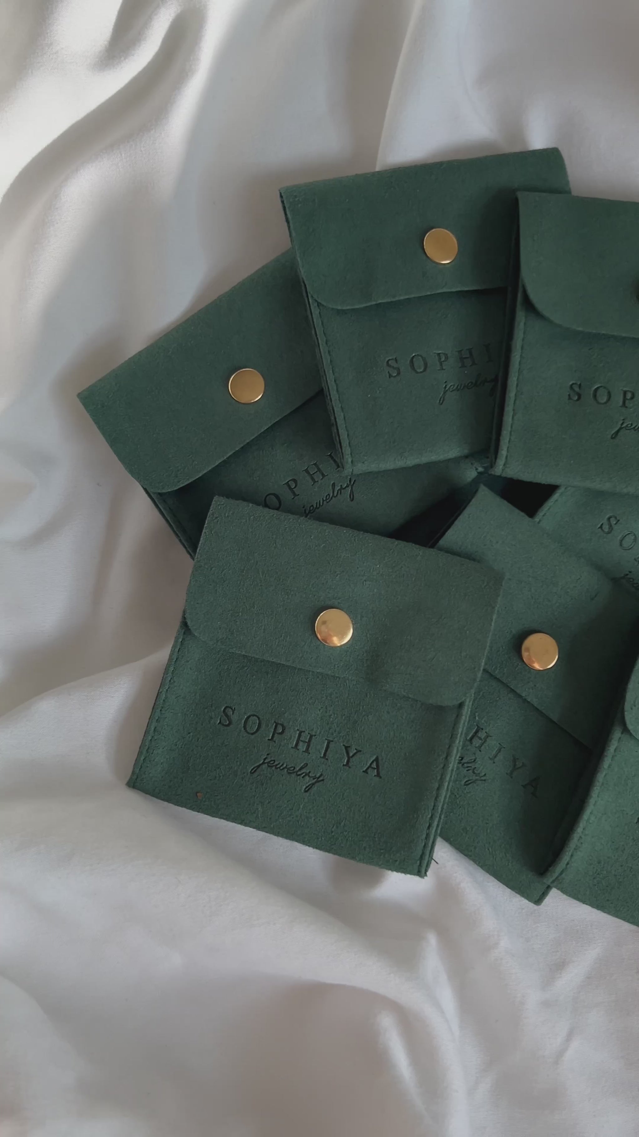 Quick cuts of unboxing silver jewelry from dark green jewelry pouches, high quality and eco friendly accessories shimmer and dazzle in the light.
