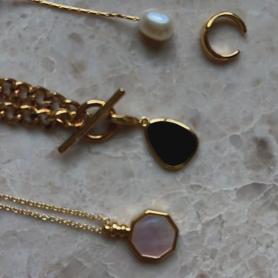 detailed close up of 18k gold plated necklaces and pearl drop earrings