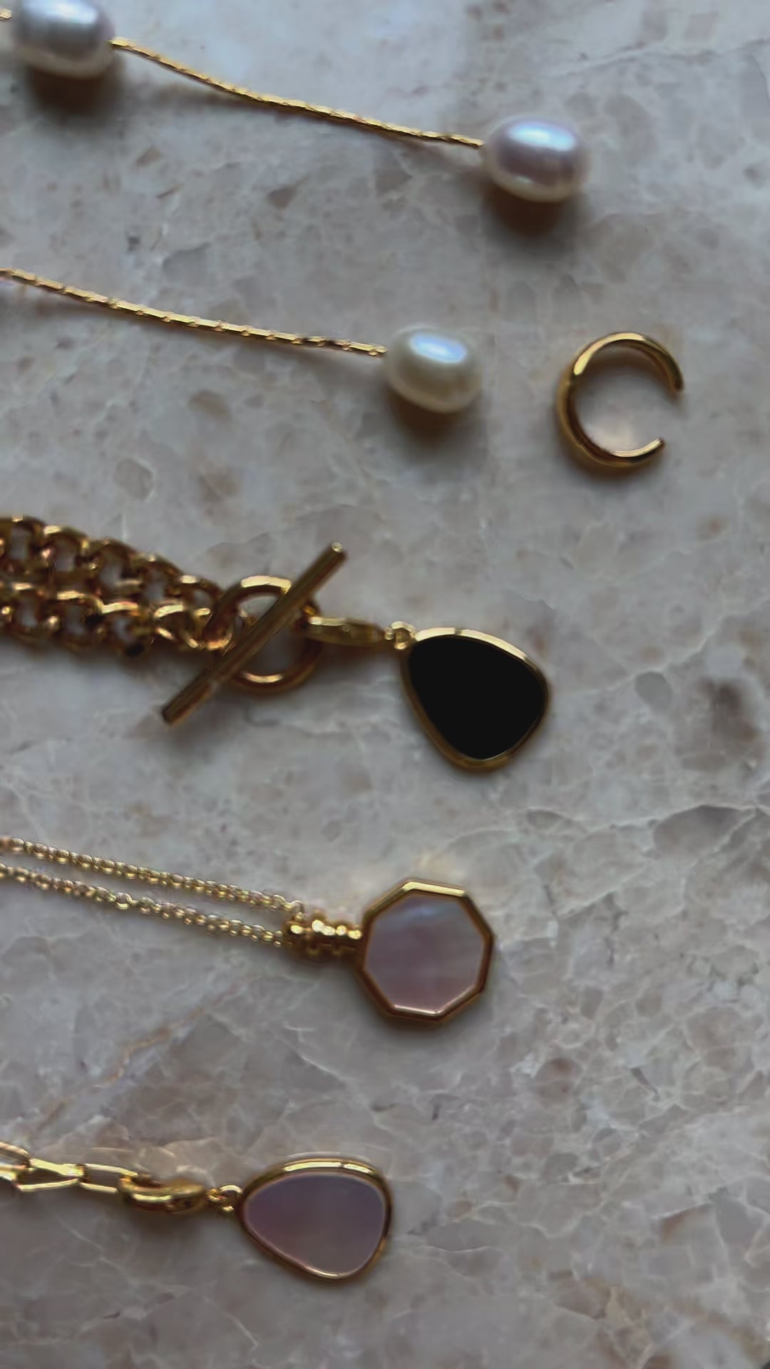 detailed close up of 18k gold plated necklaces and pearl drop earrings